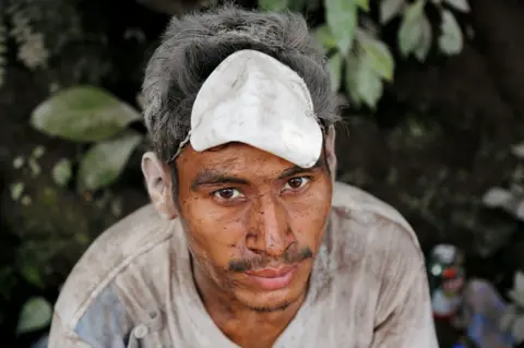 Reuters A man covered with ash