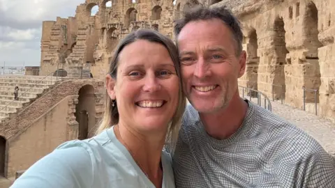 PA Media Lindsay and Craig Foreman take a selfie in front of an ancient ruin