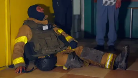 Firefighter lies on the floor exhausted
