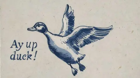 Not Quite Past A tile in a Delftware style featuring a duck in flight along with the phrase 'Ay up duck'