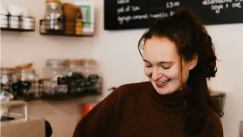 Pippa Volans A woman smiling in a bakery