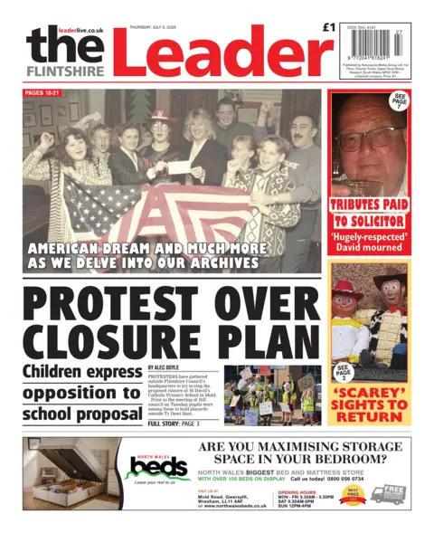 The Flintshire Leader Front page of The Flintshire Leader. Main headlines reads: Protest over closure plan; Children express opposition to school proposal. Above that is an image of people holding an American flag with the headline "American dream and much more as we delve into our archives". Next to that is a picture of a man with the headline "tributes paid to solicitor" and under that is a picture of two toy puppet figures with the headline "scarey" sights to return.