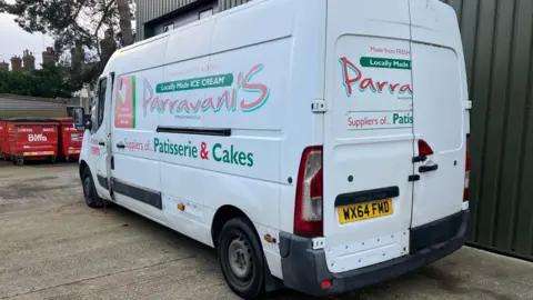 Guy Campbell/BBC A large white van displaying the Parravani's logo is parked on concrete in the loading bay of the premises.