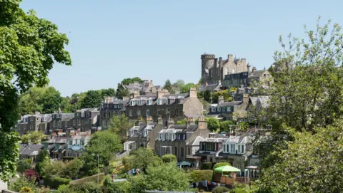 Getty Images A general view of Selkirk. A collection of stone house built in a series of terraces on the side of a hill. They are surrounded by green trees.