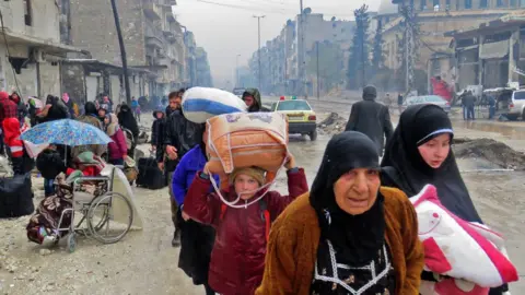 AFP Syrian civilians flee the Bustan al-Qasr district of Aleppo during fighting on 13 December 2016