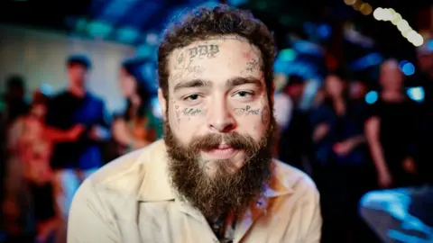 Getty Images Close-up of Post Malone in a beige shirt
