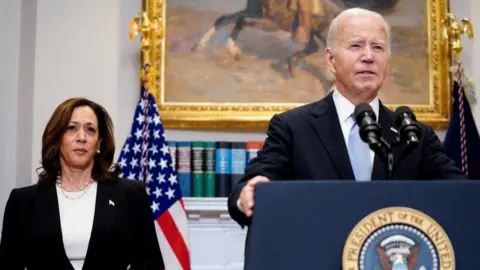 Reuters Joe Biden standing at a podium in a room in the White House making an address - Kamala Harris is standing behind him