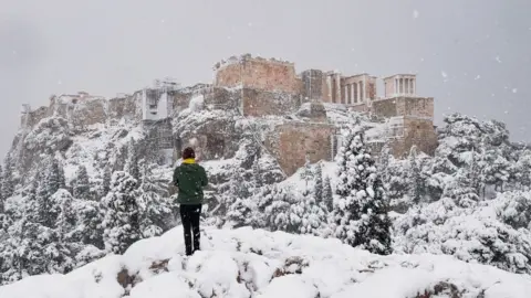 Getty Images A man takes photos of The Parthenon temple atop the Acropolis hill archaeological site
