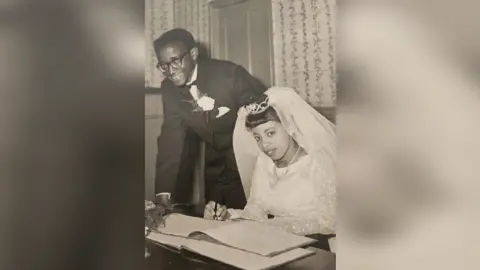 Peter Small Peter Small and his Eletha Smith wedding photo which Eletha is wearing a tiara that is holding a veil and writing on a document. 