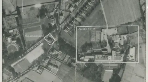 Jersey Heritage An aerial reconnaisance black and white photo of a number of buildings including the Palace Hotel.
