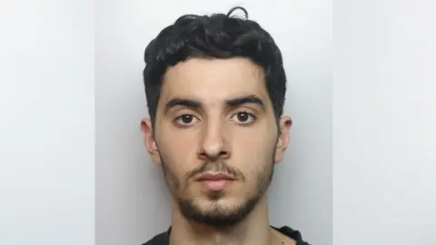 Thames Valley Police A mugshot of Ilias Almallah, who has short, black hair, a short black beard and is looking ahead, expressionless 