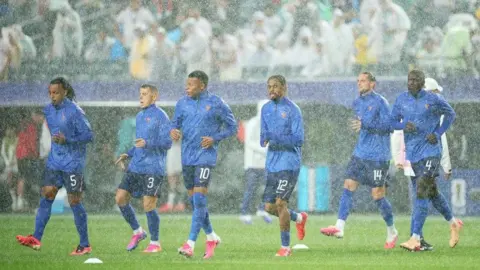 France players warm-up in heavy rain in Philadelphia at the World Cup match against Iraq