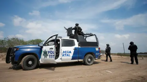 Reuters State police officers keep watch at the scene where authorities found the bodies of two of four Americans kidnapped by gunmen, in Matamoros, Mexico, March 7, 202