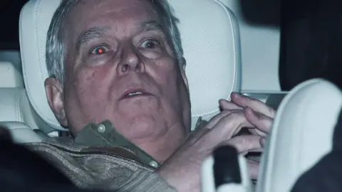 Andrew Mountbatten-Windsor in the back of a car on his release from custody.