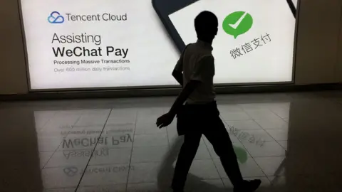 Getty Images Man walks pay WeChat Pay ad