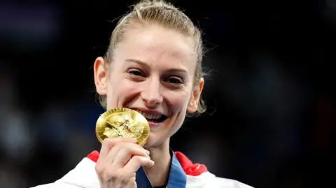 PA A smiling Bryony Page posing with her gold medal at the Paris 2024 Olympics