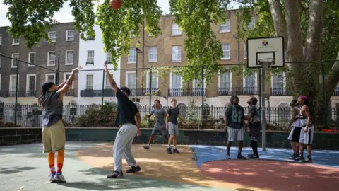 A group of people play basketball at Argyle Square Court.