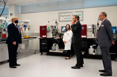 Getty Images US President Donald Trump wears a mask alongside Fujifilm Diosynth Biotechnologies