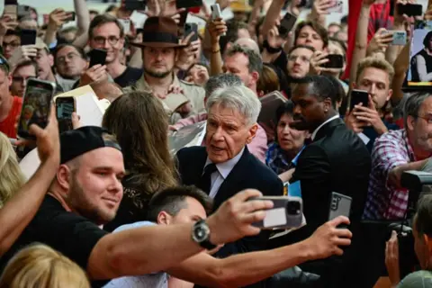 John MacDougall / AFP US actor Harrison Ford (centre) is surrounded by fans