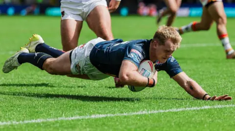 Leeds Rhinos' James McDonnell diving for the try line with the ball in his right hand to score.