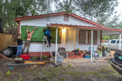  Cristóbal Herrera/EPA-EFE People boarding up windows to prepare for Hurricane Helene, in Old Town, Florida 
