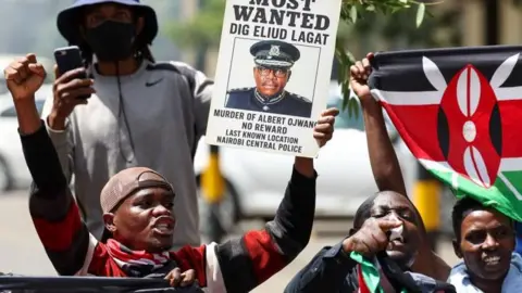 A protester holds a placard which says that the deputy police chief is a "Most wanted man" during a demonstration in Nairobi earlier this month