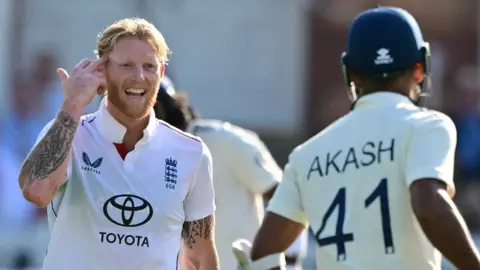 England captain Ben Stokes (left) points to his head as he gestures to India's Akash Deep (right)