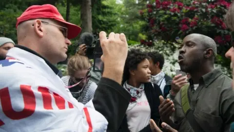 AFP A Trump supporter (left) debates with an opponent of the president (right) during a pro-Trump rally at Terry Schrunk Plaza in Portland (04 June 2017)