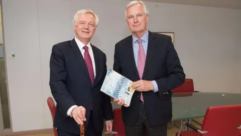 HM Government David Davis and Michel Barnier holding each other's gifts