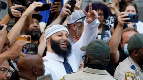 Image shows Adnan Syed celebrating outside court on Monday