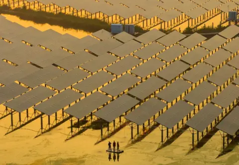 AFP Workers inspect solar panels at the fishing-solar complementary photovoltaic power generation base in Taizhou