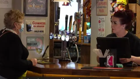 BBC Bar worker with customer in a face mask