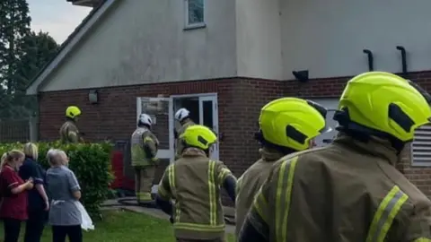 Firefighters and people standing outside a care home in Black Notley, Essex