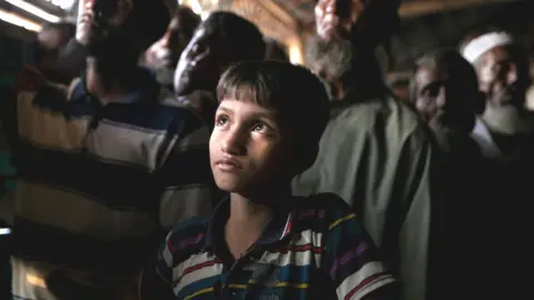 Getty Images Rohingya refugees watch ICJ proceedings at a restaurant in a refugee camp