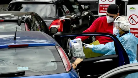 EPA Medical staff help suspected cases of Covid-19, arriving by car and waiting for available beds, outside the hospital for infectious diseases Cotugno in Naples, Italy, 12 November 2020