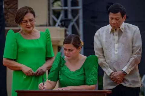 Getty Images Sara Duterte, together with her father Philippine President Rodrigo Duterte and her mother Elizabeth Zimmerman, takes her oath as the next Vice President on June 19, 2022 in Davao, Philippines.