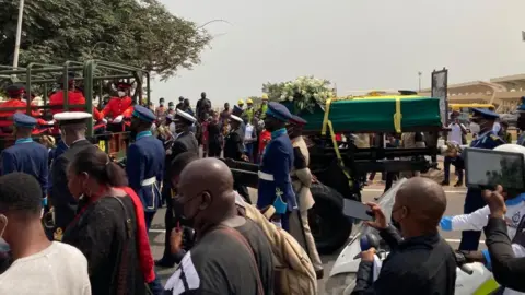 Jerry Rawling's coffin in the crowd