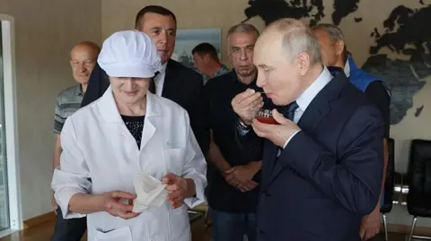 AFP via Getty Images Russia's President Vladimir Putin tastes caviar as he visits the Yasny fish processing factory on Iturup, known in Japan as Etorofu