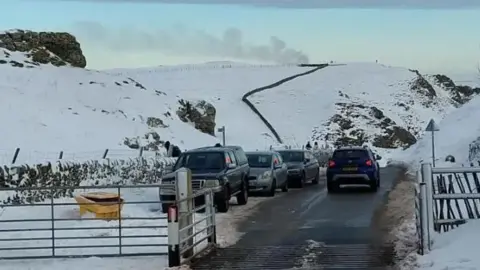 Derbyshire Police Cars parked on a clearway at Winnats Pass. There is snow on the ground