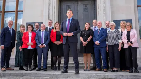 PA Media Rhun ap Iorwerth in the middle flanked by cabinet ministers
