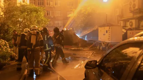 Firefighters douse flames in Kyiv.