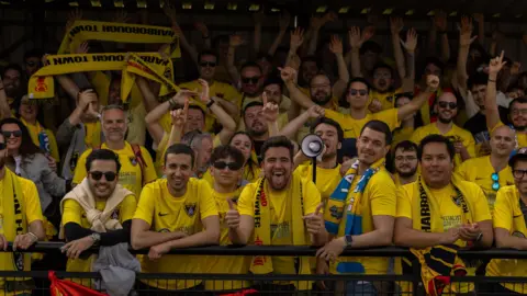 RB MEDIA Dozens of spanish football fans wearing Harborough Town football shirts