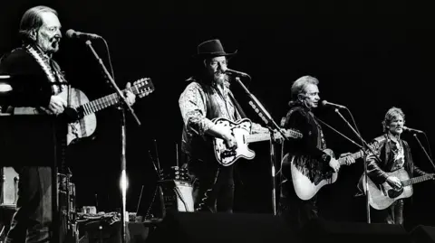 Getty Images The Highwaymen wakitumbuiza kwenye jukwaa, LR Willie Nelson, Waylon Jennings, Johnny Cash na Kris Kristofferson, Ahoy, Rotterdam, 20th April 1992. (Picha na Rob Verhorst/Redferns)
