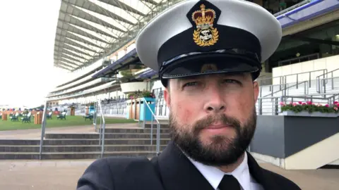 Jon Over A man in Navy Uniform taking a selfie.