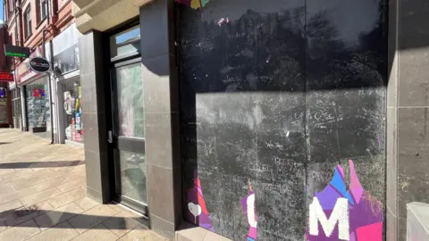 An empty boarded up shop on Bangor high street