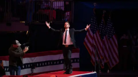 Getty Images Tony Hinchcliffe takes the stage at Madison Square Garden with his arms outstretched