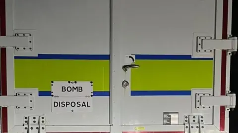 The back of a van which says BOMB DISPOSAL on it.