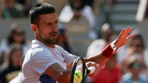 Novak Djokovic hits a return in French Open practice