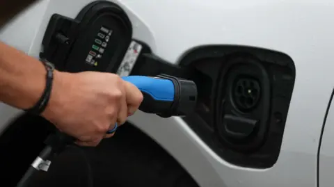 Andrew Matthews/PA Wire File photo of an electric charging cable being connected to an electric car