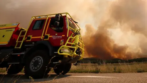 Reuters A fire engine drives as French firefighters battle a wildfire in the south-eastern Var department. Photo: 21 July 2026